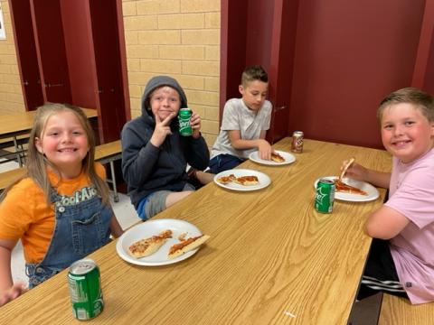 Rees boys and one girl enjoying their pizza and soda