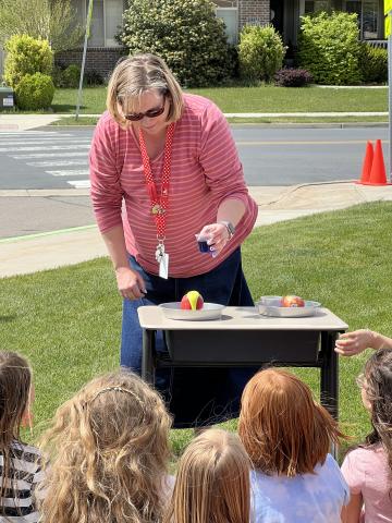 Mrs. Darrington demonstrating an experiment to second grade students. 