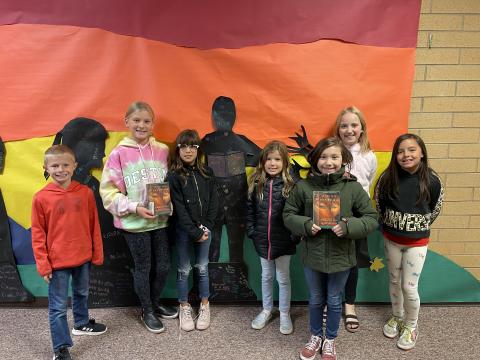 Rees 4th Grade students with the book Riding Freedom standing in front of the characters they made from the book
