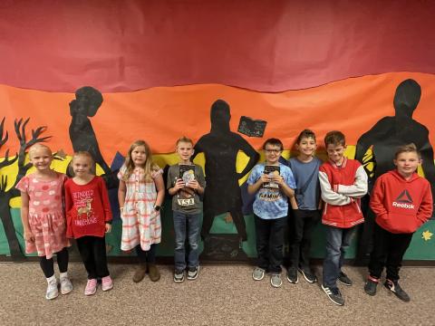 Rees 4th Grade students with the book Number the Stars standing in front of the characters they made from the book