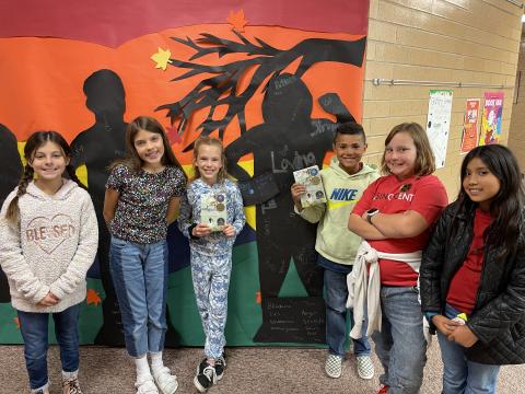 Rees 4th Grade students with the book As Brave as You standing in front of the characters they made from the book