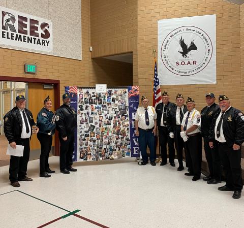 All of the Veterans who came to Rees standing by our Wall of Honor with pictures of family and friends of students at Rees