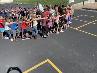 Second grade students playing in a circle outside for fun Friday 