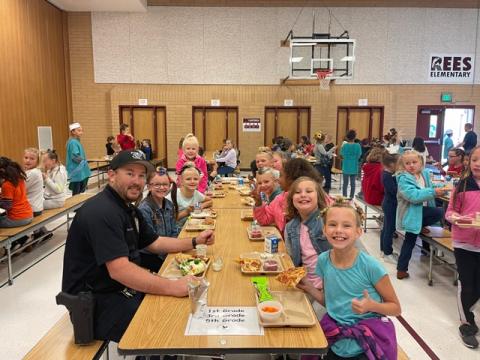 Police officer eating lunch with students