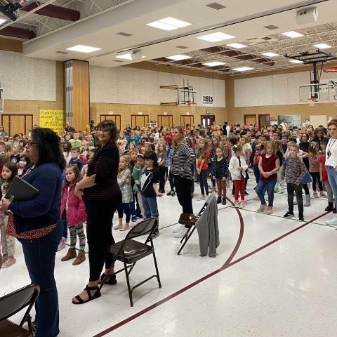Rees students standing during the assembly 