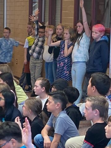 4th grade students raising their hands to ask questions during K9 visit