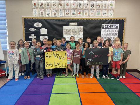 Miss Phillips 1st grade class with two signs showing their love and support of her.