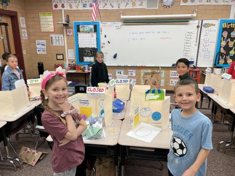 Second grade boys and girls selling items at their store