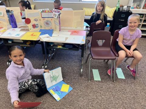 Second grade girls sitting at their store (desk)