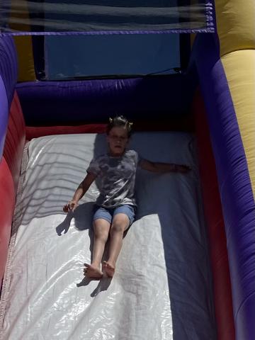 Girl sliding down at the bounce house