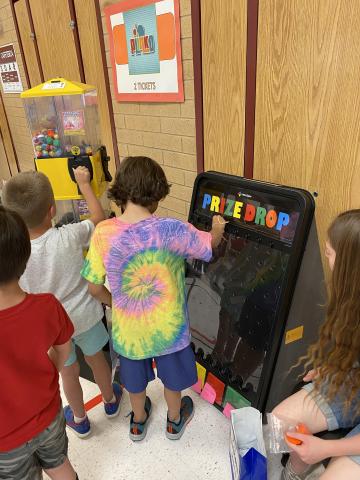 Rees boys playing Plinko and getting prizes from the token machine