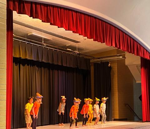 Rees kindergarten students dancing with animal hats on at their graduation