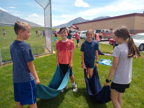 4th grade girls and boys standing with their towels during water balloon toss.