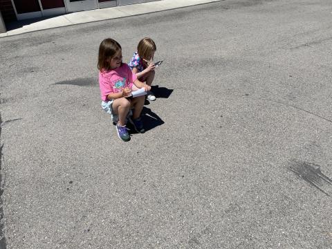 Two second grade girls doing math activities outside in the sunshine
