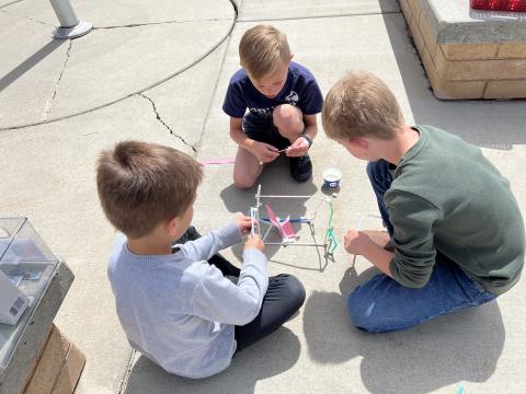 Three second grade boys constructing their houses for the three little pigs. 