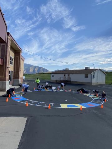 Group of volunteers painting the shape circle outside