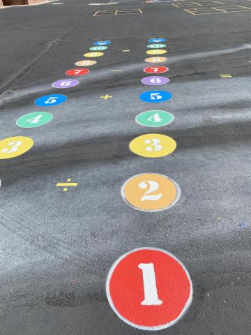 Two number caterpillars painted  bright colors on the playground outside