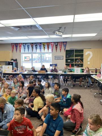 Rees younger students listening to 5th grade students share their state reports. 