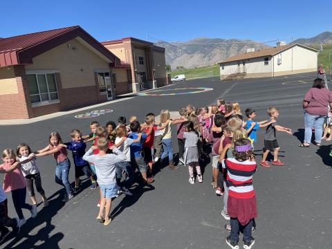Second grade students outside playing in a line together