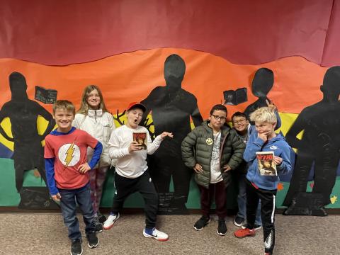 Rees 4th Grade students with the book Wringer standing in front of the characters they made from the book