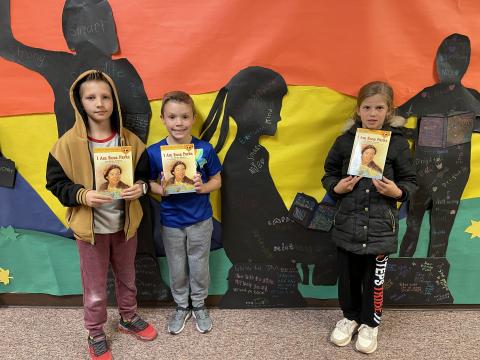 Rees 4th Grade students with the book I am Rosa Parks standing in front of the characters they made from the book