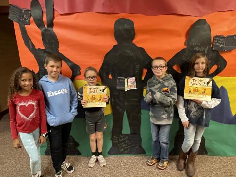 Rees 4th Grade students with the book Those Shoes standing in front of the characters they made from the book