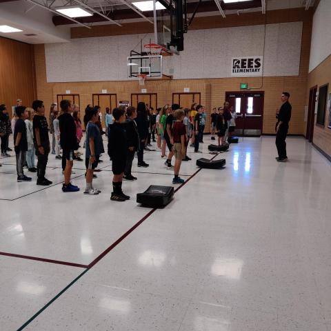 Rees 5th grade students standing in lines in the gym learning about karate