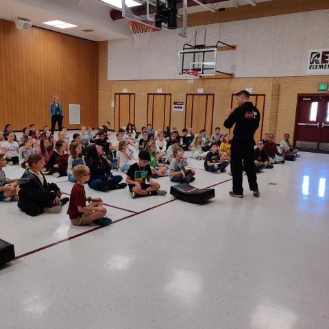 Rees 5th grade students sitting in the gym learning about standing up to bullying