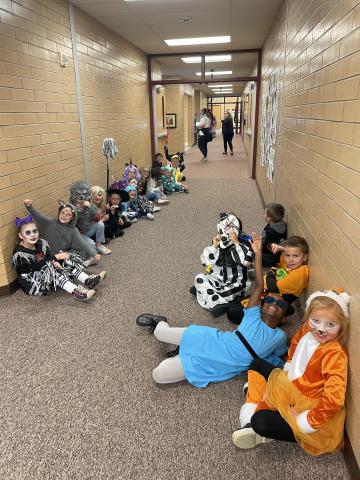 Second graders sitting in the hall wearing their costumes watching the parade