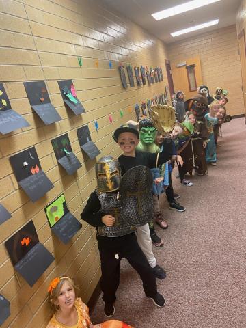 Mrs. Roberts second grade class in the hallway dressed in their costumes watching the Halloween parade