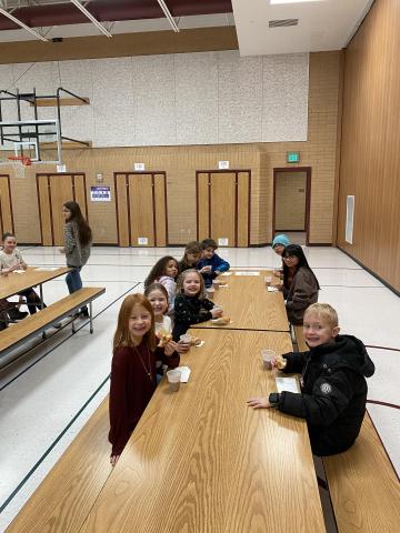 Rees boys and girls enjoying their donuts and chocolate milk sitting at a table