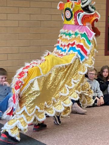 Students sitting and watching a dragon during Lunar New Year performance