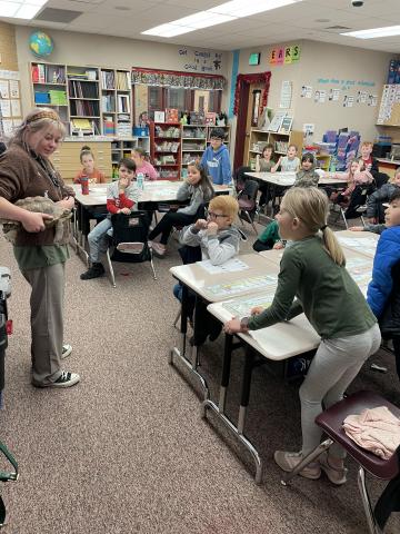 Students looking at a turtle during their class visit from Hogle Zoo