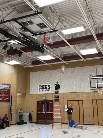Mr. Jimmy on a ladder and Mr Cook helping during the egg drop. Throwing another egg contraption. 