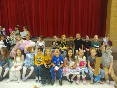 Students from Mrs. Bodily's class dressed up as nursery rhyme characters sitting on the stairs. 