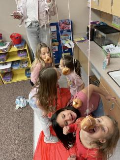 2nd grade girls having fun eating donuts hanging from a string