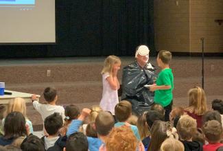 Young students putting "pie" in Mr. Gull's face. 